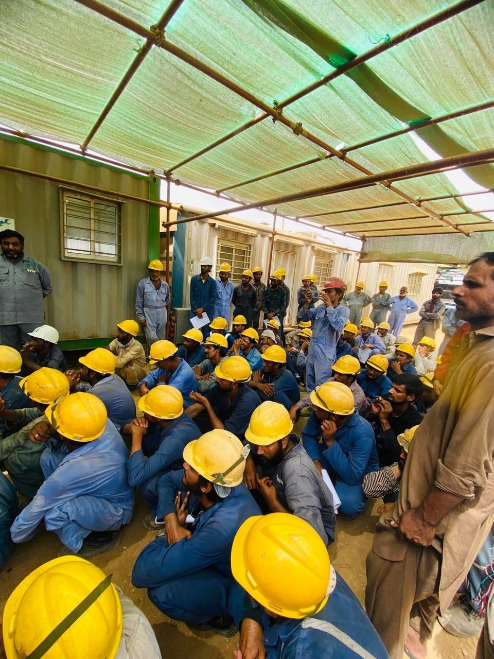 Workers in hard hats attending an HSE toolbox talk session